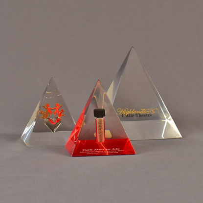 Grouping of three pyramid acrylic embedments awards - one with a dirt sample, one with brass images and one with text.