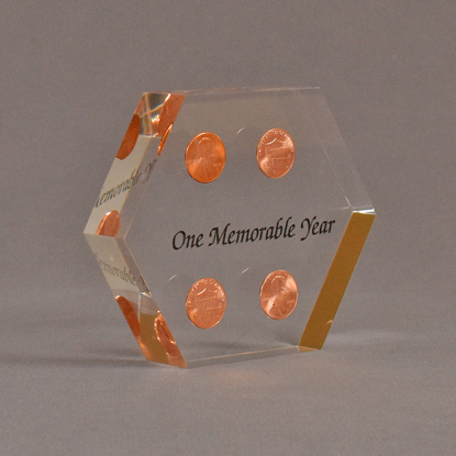 Angle view of 4" x 5" hexagon acrylic embedment award with four pennies cast in clear acrylic and black text.