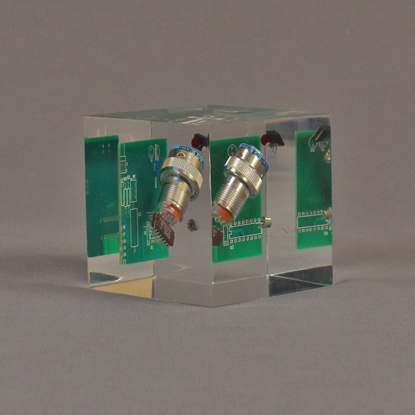Angle view of 3" cube acrylic embedment award with electronic component cast into crystal clear acrylic.