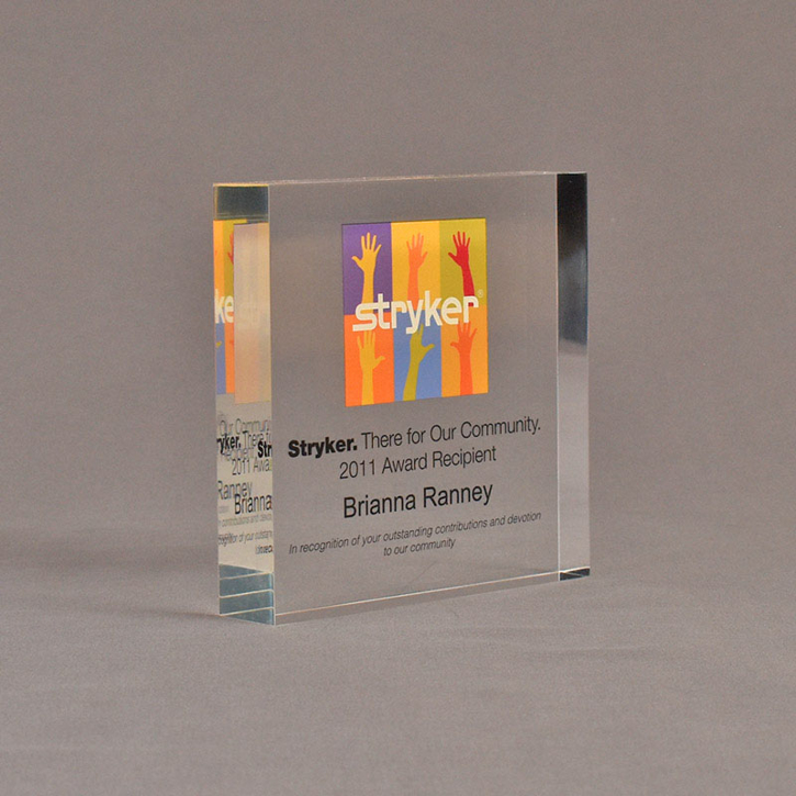 Angle view of 5" square acrylic embedment award with Stryker logo and acetate printed text cast into acrylic.