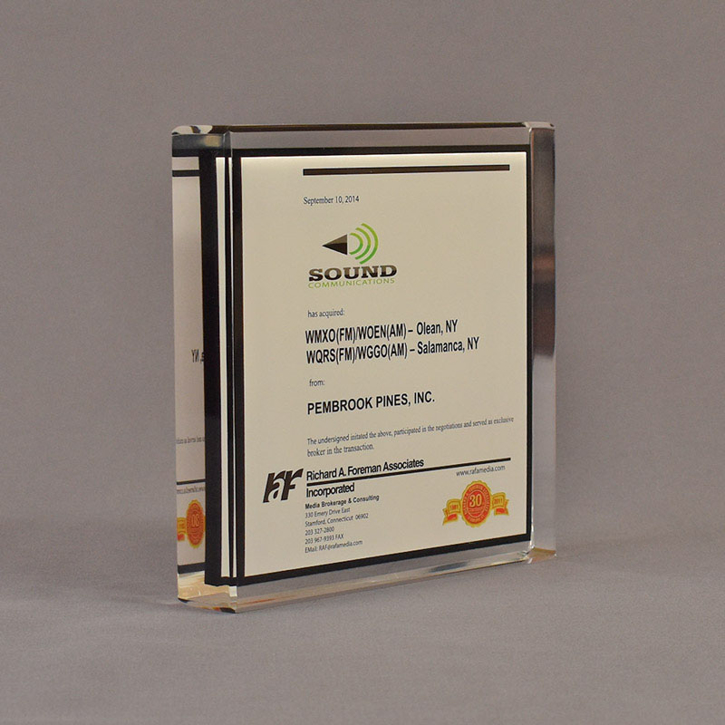 Angle view of 6" square acrylic embedment award with Sound Comunications logo and text cast in acrylic.