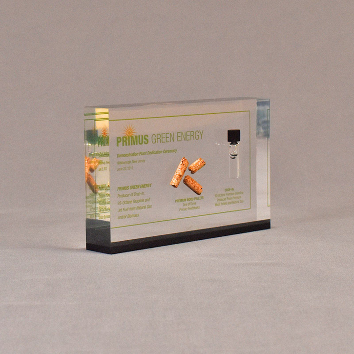 Angle view of 4" x 6" rectangle acrylic embedment award with wood pellets and oil vial cast into clear acrylic.
