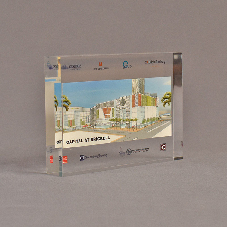 Angle view of 5" x 7" rectangle acrylic embedment award with Capital at Brickwell logos cast into clear acrylic.