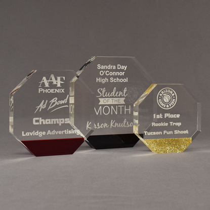 Three ColorCast™ Octagon Acrylic Awards grouped showing red transparent, black and gold glitter accent color options.