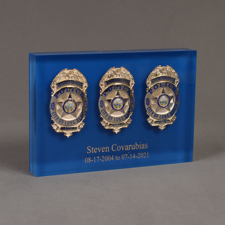 Angle view of Lucite® Badge Embedment with two police and one marine supervisor service badges cast inside clear acrylic.