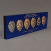 Side view of Lucite® Badge Embedment with six career service badges cast inside clear acrylic with laser engraved text.