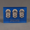 Front view of Lucite® Badge Embedment with two police and one marine supervisor service badges cast inside clear acrylic.