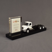 Side view of the Best Trash Deal Toy featuring acrylic embedding, paper printing and a custom black acrylic base to house a customer supplied toy and financial tombstone.